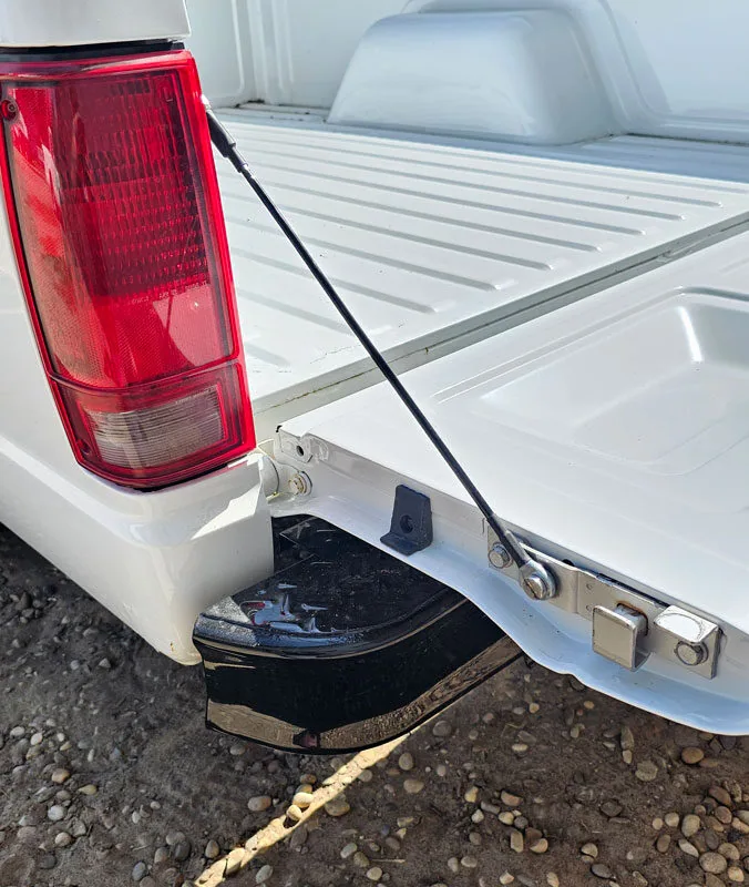 Tailgate cable installed on the tailgate of a white Chevy S10 truck